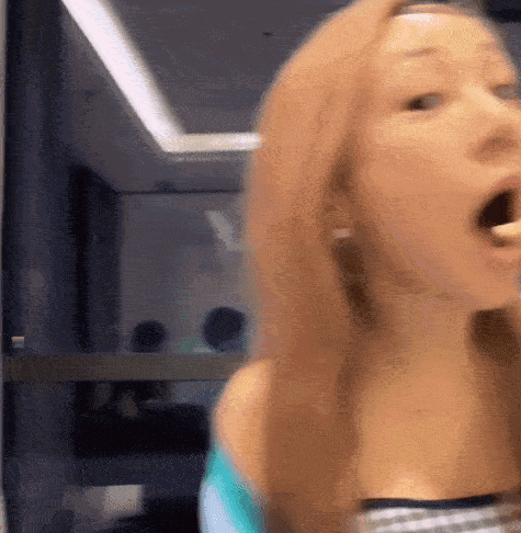 a woman with her mouth open is looking at the camera