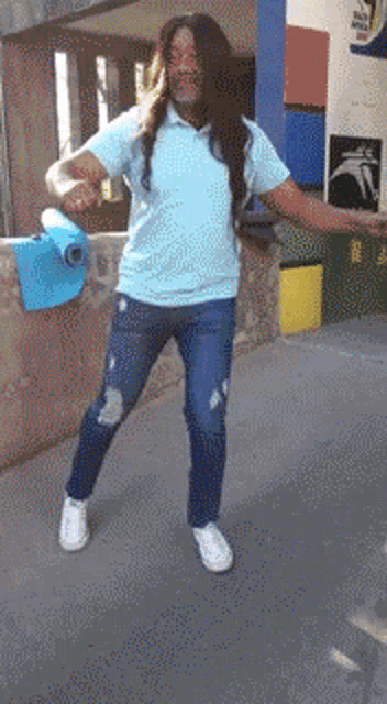 a man in a blue shirt and jeans is holding a blue bucket