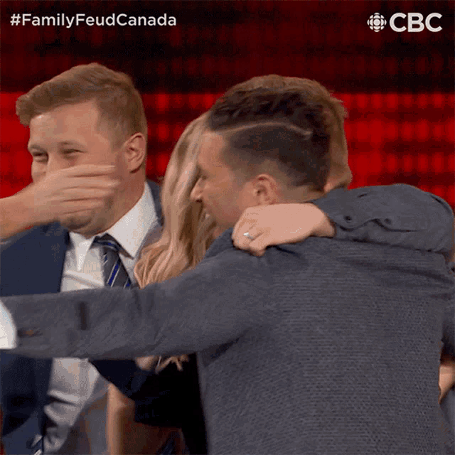 a group of people are hugging each other with a cbc logo in the background