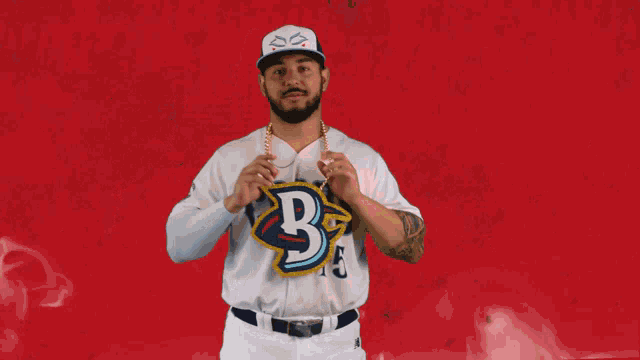 a man wearing a baseball uniform with the letter b on the front