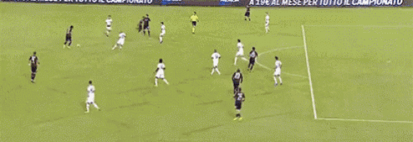 a soccer goalie is diving to catch the ball in front of a caffe borbone banner