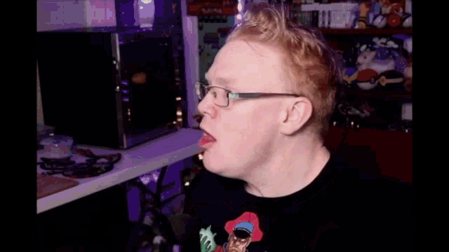 a man wearing glasses and a t-shirt with a cartoon character sticking his tongue out