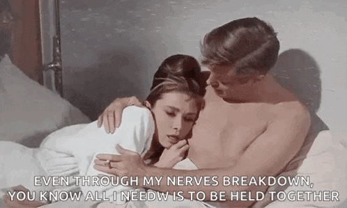 a man and a woman are laying on a bed . the man is hugging the woman .