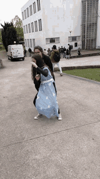 a woman in a blue dress is walking down a sidewalk next to a white van