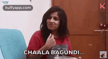a woman in a red shirt is sitting in a chair and saying chaala bagundi