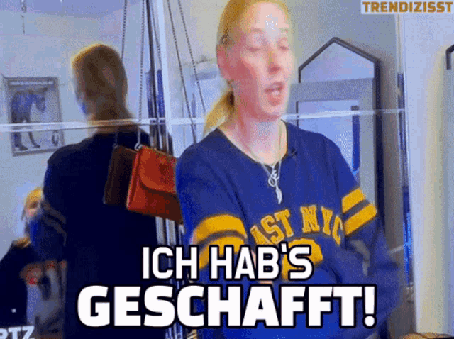 a woman standing in front of a mirror with the words ich hab 's geschafft