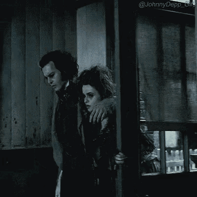 a man and woman are standing next to each other in a dark room .