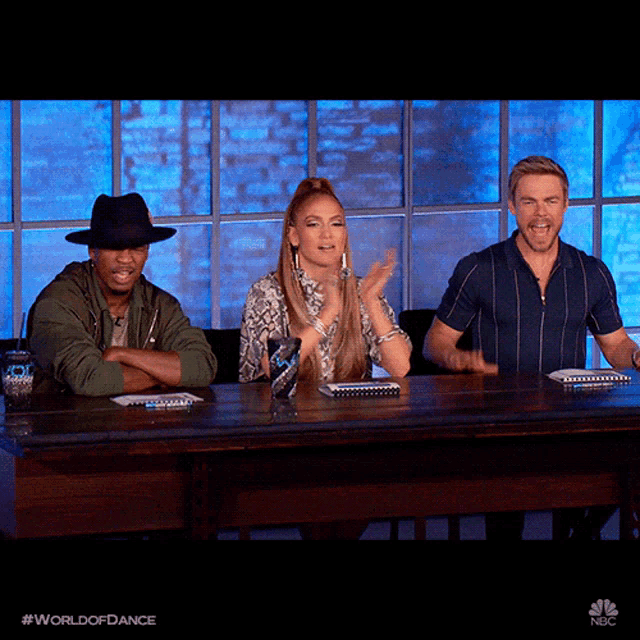 three people sitting at a table with the word world of dance on the bottom right