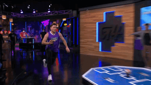 a man in a purple jersey with the word crow on it is running
