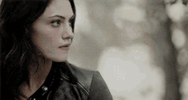 a close up of a woman wearing a black leather jacket