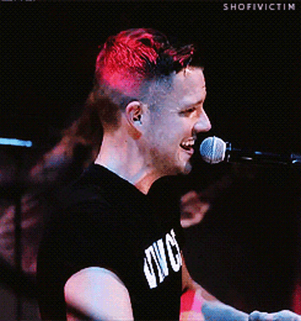 a man with red hair singing into a microphone with shofiivictim written on the bottom