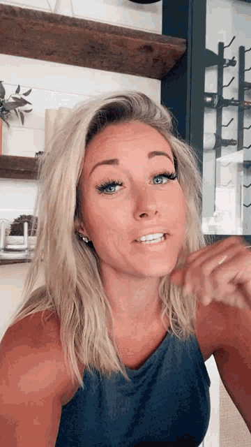 a woman with blonde hair and blue eyes is smiling for the camera
