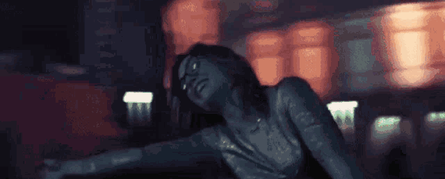 a woman is laying down with her arms outstretched in front of a building .