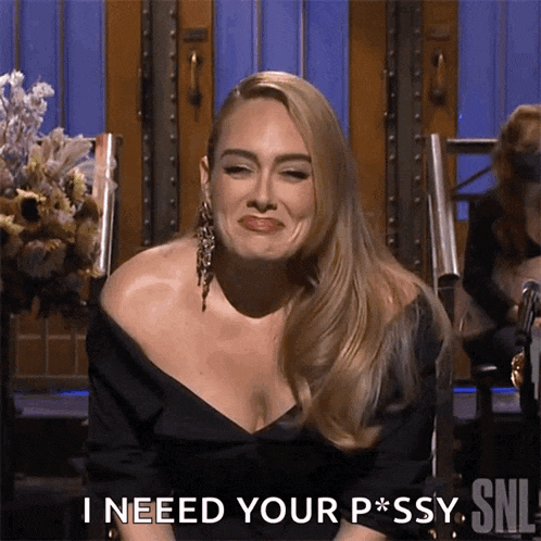 a woman in a black dress is sitting in front of a sign that says i need your p * ssy