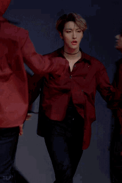 a man in a red shirt and black pants dancing
