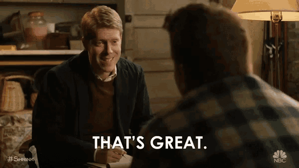 two men are sitting at a table and one of them is saying that 's great ..