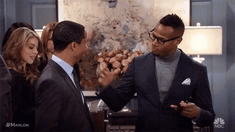 two men in suits and glasses are standing next to each other and shaking hands .