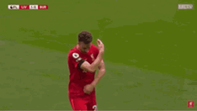 a group of soccer players are high fiving each other on a field .