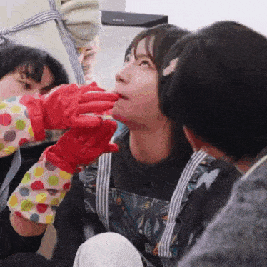 a woman wearing polka dot aprons and red rubber gloves