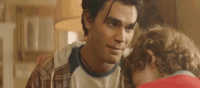 a man and a child are looking at each other . the man is wearing a plaid shirt .