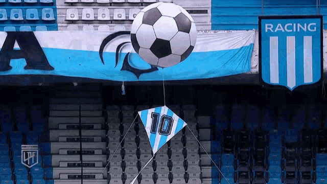 a kite with the number 10 on it is flying in front of a racing banner