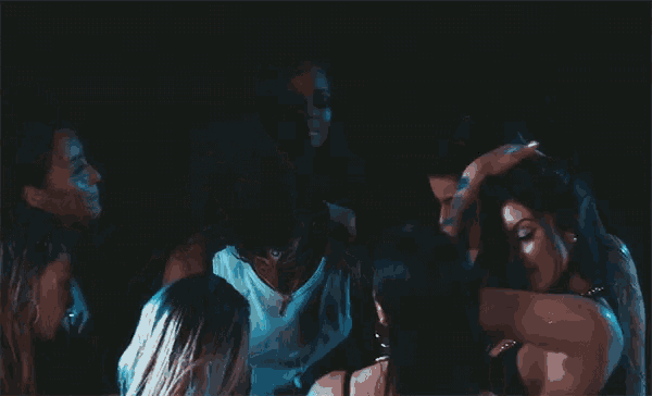 a man with a mustache is surrounded by a group of women .