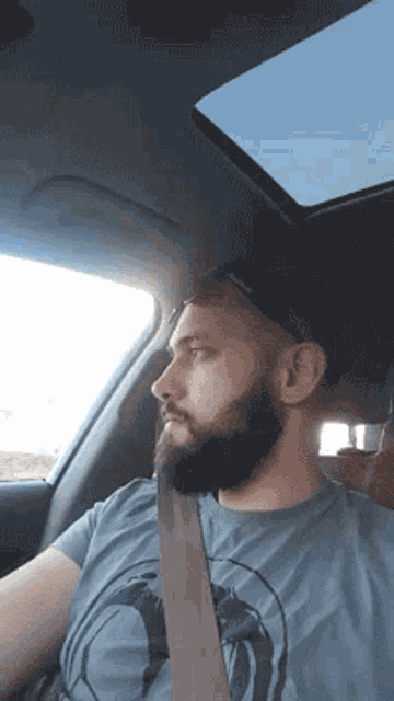 a man with a beard is wearing a seat belt