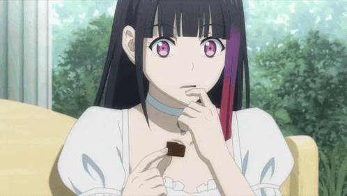 a girl with long black hair and pink eyes is eating a piece of chocolate