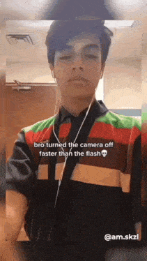 a young man wearing headphones and a burger king shirt is taking a selfie .