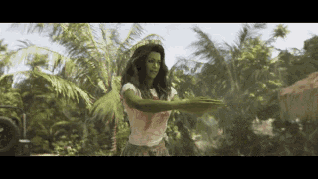 a woman with green arms is standing in a tropical area