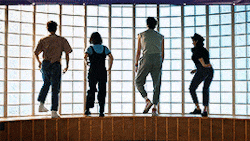 a group of people standing in front of a glass wall