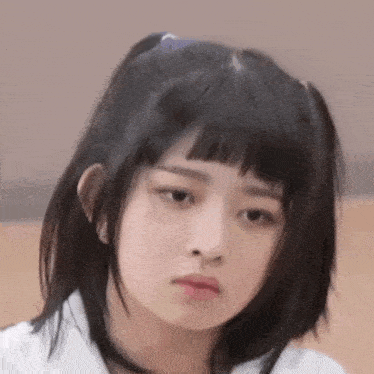 a close up of a girl making a funny face with her hair in pigtails .