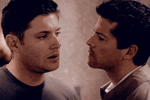 two men are standing next to each other and looking at each other with their mouths open .