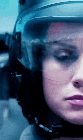 a close up of a woman 's face with a helmet on