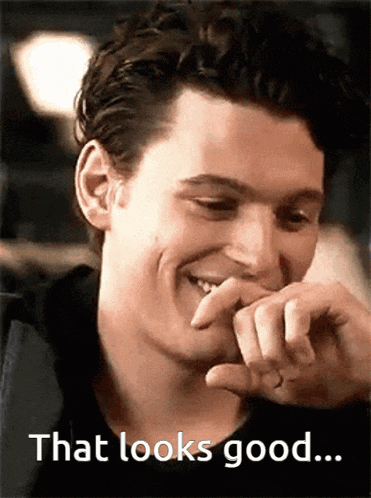 a man is smiling and covering his mouth with his hand with the words that looks good below him