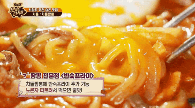 a close up of a bowl of noodles with chopsticks and foreign writing on the bottom