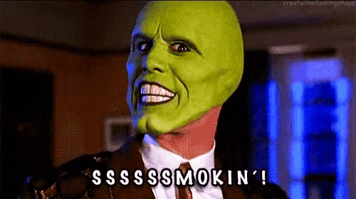 a man in a suit and tie with a green mask on his face says sssss smokin ' !