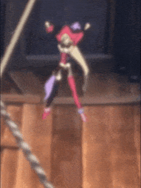 a cartoon character is hanging from a rope on a wooden table .