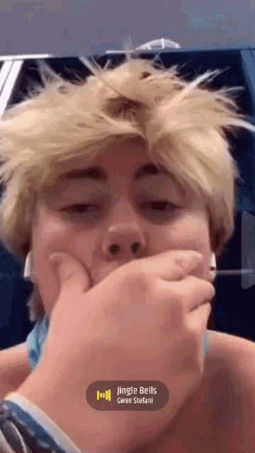 a person covering their mouth with their hand and the song jingle bells is playing