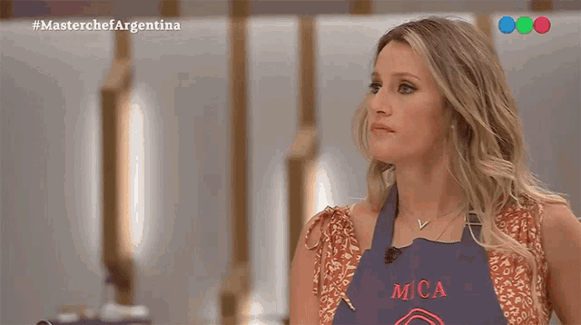 a woman wearing a blue apron that says mca