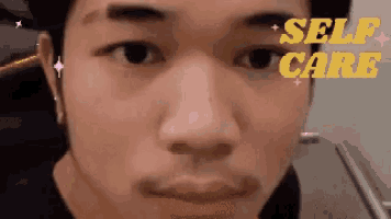 a close up of a man 's face with the words self care in yellow letters