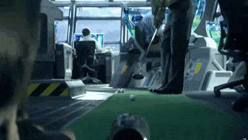 a man is playing a game of golf in a room