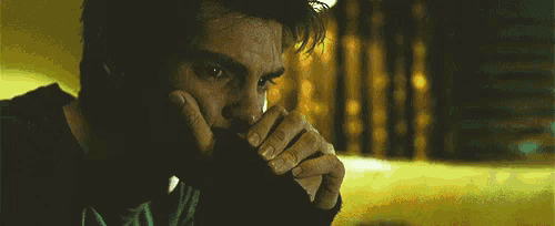 a close up of a man 's face with his hands on his face
