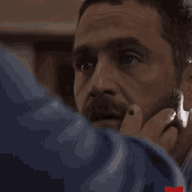 a man with a beard is being touched by another man .