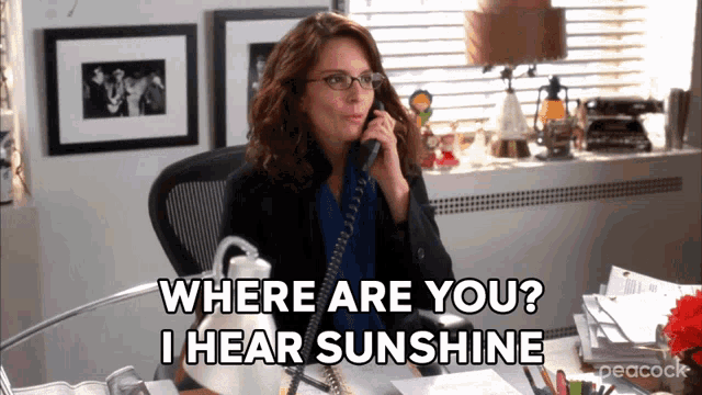 a woman sitting at a desk talking on a phone with the words where are you i hear sunshine above her