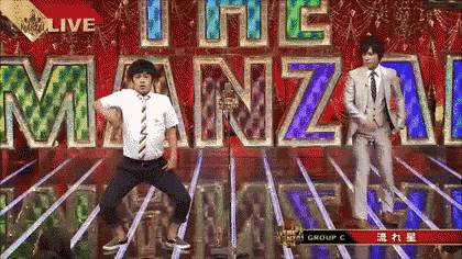 a man in a suit and tie is dancing in front of the word manzai