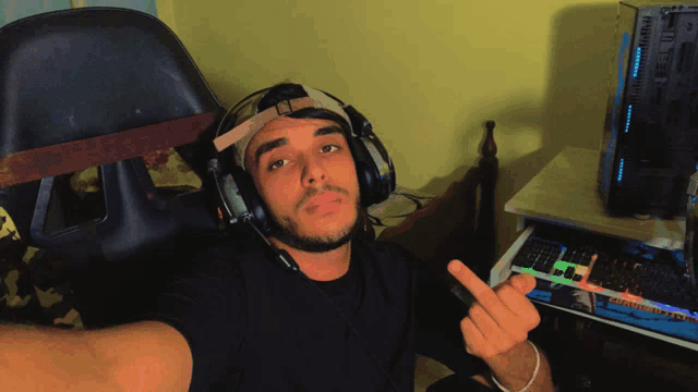 a man wearing headphones and a headband shows the middle finger