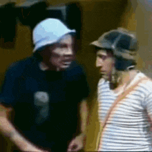 two men wearing hats are standing next to each other .