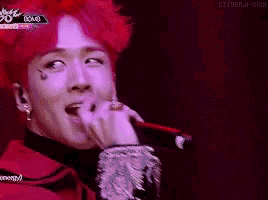 a man with red hair is singing into a microphone