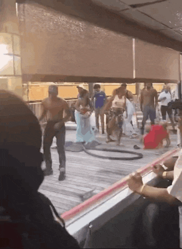 a group of people are standing on a deck with a hula hoop